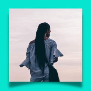 a photo of a woman with her back to the camera and facing the ocean